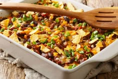 a casserole dish with beans, corn and tortilla chips in it