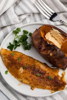 a white plate topped with an eggplant and baked potato next to a fork