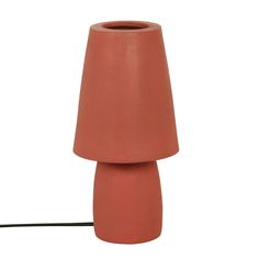 an orange ceramic lamp with a black cord attached to the base and a white background