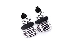 These black and white earrings are a super fun accessory to top off an outfit. Each earring features solid black acrylic charms paired with black and white triangle print and chevron charms. They are the perfect mix of patterns that is far from boring! The earrings are finished off with stainless steel ear posts. MATERIALS Acrylic Stainless Ear Posts LENGTH 2 1/4" CARE Direct contact with perfumes and moisture should be avoided to minimize damage or discoloration. Please remove before showering, Bold Black Drop Earrings, Trendy Black Geometric Earrings, Trendy Black Geometric Jewelry, Black And White Earrings, Black Earrings Dangle, Triangle Print, Acrylic Charms, Black Acrylic, White Jewelry