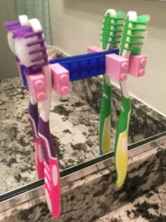 two toothbrushes are placed in front of a mirror on the counter top,