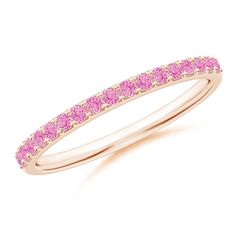 a yellow gold ring with pink sapphire stones on the sides and a thin band around it