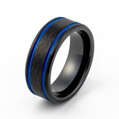 a black and blue wedding ring with an interior inlayed to the side, on a white background