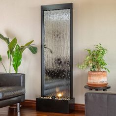 a living room with a large water fountain in the center and a potted plant next to it