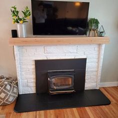 a living room with a fire place and television on the wall above it is shown