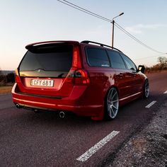 a red minivan is parked on the side of the road