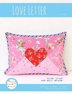 a pink pillow with a red heart on it and the words love letter written in blue