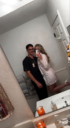 a man and woman taking a selfie in the bathroom