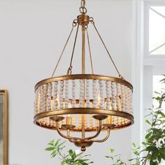 a chandelier with beads hanging from it's centerpiece in a living room