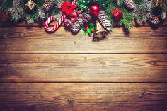 pine cones, candy canes and other christmas decorations on a wooden background with copy space