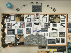 an astronaut statue on top of a rock in front of a bulletin board