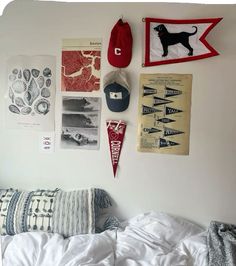 a bed with pillows and pictures on the wall above it, along with other items