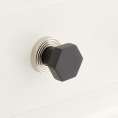 a black knob on a white door with an octagonal design in the front and center