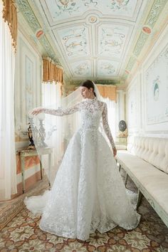 a woman in a white wedding dress is posing for the camera