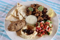 a white plate topped with different types of food on top of a blue and white table cloth