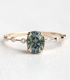 an engagement ring with a green diamond in the center