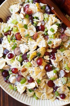 pasta salad with grapes, celery, and almonds in a wooden bowl