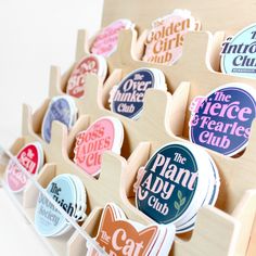 a bunch of stickers that are on top of a wooden holder with magnets