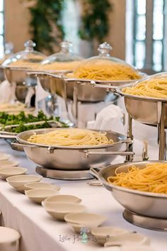 a buffet table with pasta and vegetables on it