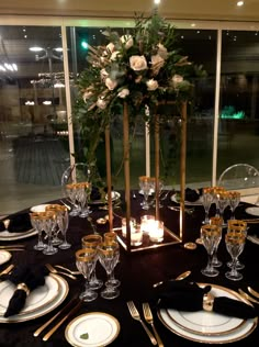 the table is set with black and gold place settings