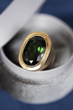 Vintage one-of-a-kind handcrafted solid 18k yellow gold bezel set ring featuring a very impressive natural green tourmaline gemstone in the center. The tourmaline is a deep rich green with a total carat weight of 11.65 carats measuring 20mm x 13mm. The tourmaline has lightly abraded crown facets and it is moderately included. Ring size 6 1/2 (NZ/UK: M 1/2). The gold has a beautiful vintage brushed finish and was beautifully handcrafted in solid heavy 18k yellow gold. Hallmarked 18ct.  Item condi Oval Tourmaline Emerald Ring With Bezel Setting, Gold Ring Unique, Gold Hat, Green Tourmaline Ring, Vintage Brush, Bezel Set Ring, Ring Bezel, 18k Yellow Gold Ring, Tourmaline Ring