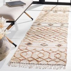 a white rug with an intricate design on the floor next to a bench and window