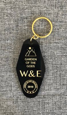 a black and gold keychain with the words garden of the gods w & e on it