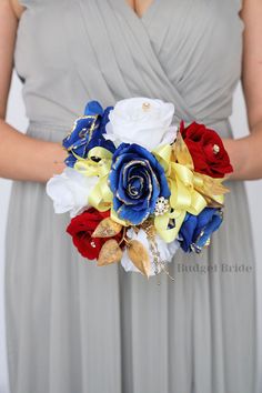 a woman in a gray dress holding a bouquet with red, white and blue flowers