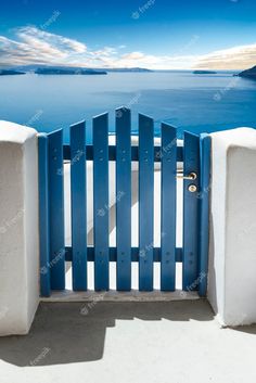 an open blue and white gate overlooking the ocean