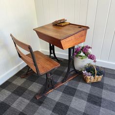 a wooden desk and chair with flowers on the floor