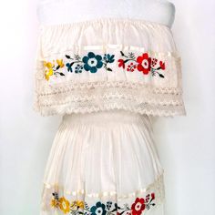 100% Artisanal Garment - Made In Mexico. Finely Embroidered Dress Made By The Artisans From Puebla. Embroidered Flowers In The Front. Flowy And Frilly, With Lace Layers On The Borders. The Waist Of The Dress Has Elastic, Which Adapts To Your Body Shape. This Is An Artisan Piece, Each Of These Dresses Is Unique So There May Be Slight Variations In The Colors Of The Flowers. This Type Of Dress Requires The Talent Of Many Artisans Who Share A Passion For Mexican Culture. Add A Touch Of Fiesta And V Traditional Lace Dress With Floral Embroidery, Folk Style Beige Dress With Floral Embroidery, Traditional Embroidered Lace Dress, Traditional Cream Dress With Floral Embroidery, Cream Cotton Dress With Floral Embroidery, Cream Cotton Dress With Intricate Embroidery, Traditional Off White Dress With Floral Embroidery, Off White Lace Dress With Floral Embroidery, Off White Dresses With Intricate Embroidery For Summer