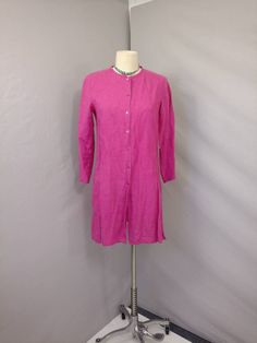 "Soft surface and rich color on this vintage linen tunic shirt jacket. The label is Eileen Fisher, fabric content 100% linen. Photographed un ironed. Natural slightly nubby linen surface, mid weight, color is a wonderful dark magenta pink - not quite as bright/ florescent looking as it photographed. Shape is slim tunic style with a skinny band collar and button front all the way down, deep side slits & long sleeve. Size is marked XS, shown on a 6mannequin, please go by measurements. Machine Spring Button-up Tunic With Buttons, Casual Linen Long Sleeve Dress With Button Closure, Casual Long Sleeve Linen Dress With Button Closure, Button-up Tunic For Daywear, Long Sleeve Linen Blouse With Button Closure, Long Sleeve Linen Dress With Buttons For Work, Vintage Linen Long Sleeve Blouse, Vintage Long Sleeve Linen Blouse, Spring Linen Tunic With Buttons