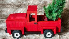 a red toy truck with a christmas tree in the back