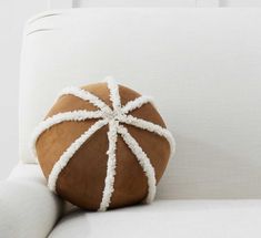 a brown and white pillow sitting on top of a white couch