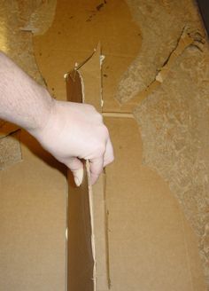 a person cutting up some cardboard with a pair of scissors