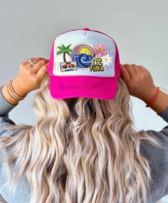 the back of a woman's head wearing a pink and white trucker hat