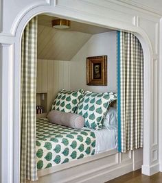 a bed sitting under a window next to a wooden floor