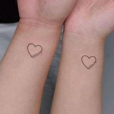 two wrist tattoos with hearts and words on the wrists, one has a small heart