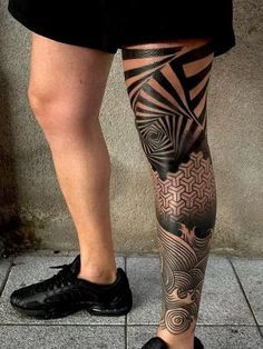 a man's legs with tattoos on them