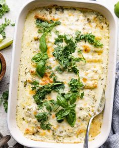 a casserole dish filled with cheese and greens