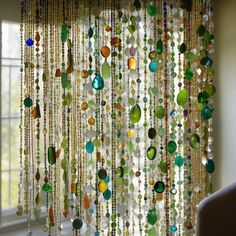 a curtain made out of glass beads hanging from the side of a window