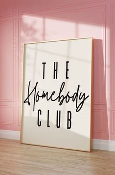 a sign that says the home body club on it in front of a pink wall