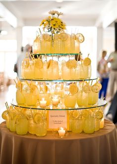 there is a cake made out of jars with candles in them and flowers on top