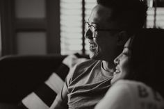 a man and woman sitting on a couch laughing