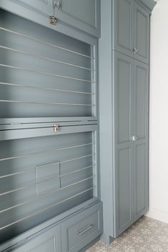 an empty room with gray cupboards and drawers in the wall, along with carpeted flooring