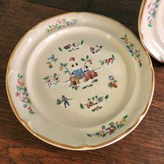 two plates sitting on top of a wooden table next to each other with designs on them