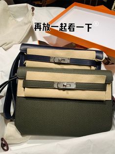 three purses sitting on top of each other in front of a white box with chinese writing