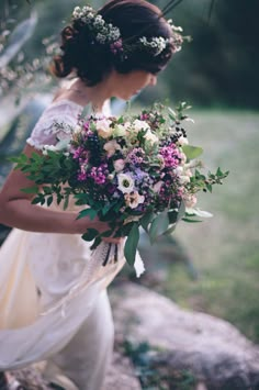 a woman holding a bouquet of flowers in her hands