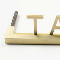 the word talk spelled with wooden letters on a white surface next to a metal screw