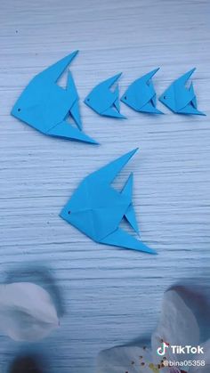 four blue paper fish are on the table